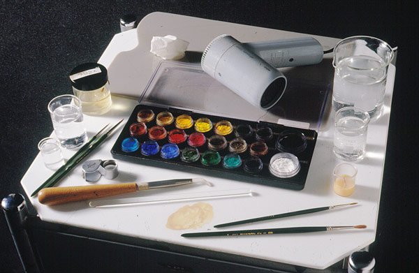 tools for tempera retouching, including dry pigments, brushes, burnishing tool, egg tempera, and synthetic varnish